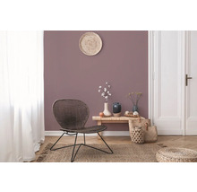 Woonkamer met rotan stoel, houten tafel en decoraties op een tapijt