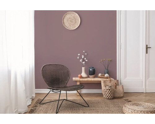 Woonkamer met rotan stoel, houten tafel en decoraties op een tapijt