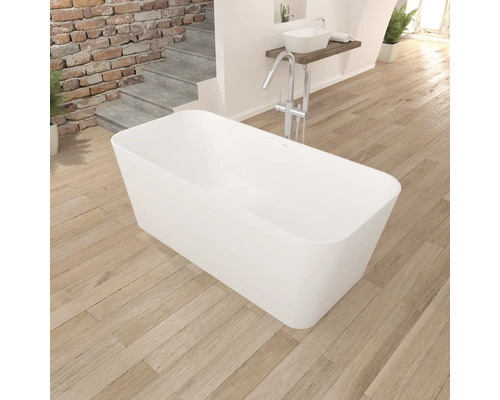 Vrijstaand bad in badkamer met houten vloer en wastafel