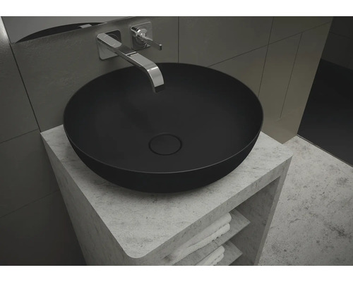 Zwarte opzetwastafel op een wastafelmeubel met handdoeken