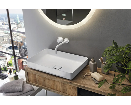 Badkamer met opzetwastafel, kraan en spiegel met verlichting op een houten wastafelmeubel