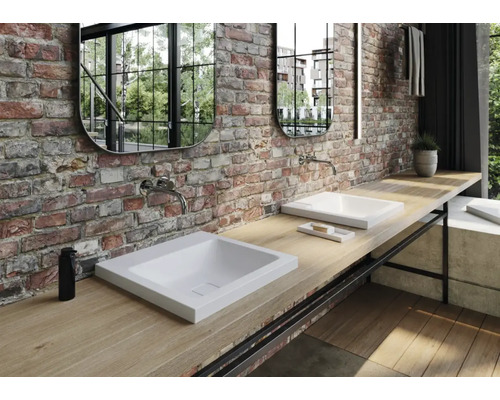 Badkamer met wastafels, kranen, spiegels en houten werkblad tegen bakstenen muur