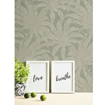 Decoratief behang met plantenmotief, aangevuld met fotolijsten en decoratie