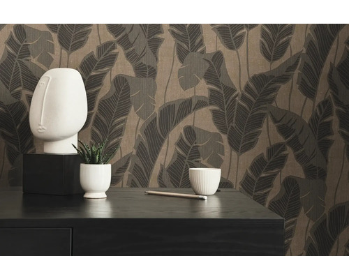 Decoratieve opstelling met behang, sculptuur, plant, potlood en schaal op een dressoir