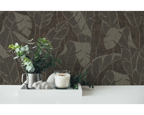 Decoratief behang met plantenpatroon en een arrangement van kaars, plant en decoratief figuur op een tafel