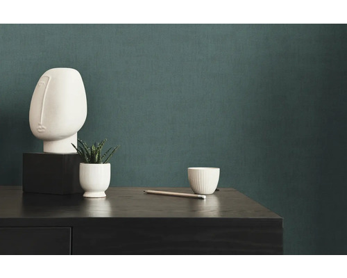 Decoratieve scène met een abstract beeldhouwwerk, een vetplant en een potlood op een commode.