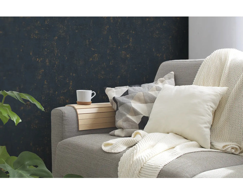 Woonkamer met grijze bank, kussens, deken en houten tafel