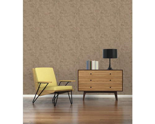 Woonkamer met fauteuil, commode, lamp en boeken voor een bruine muur