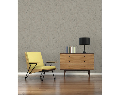 Woonkamer met fauteuil, commode en behang met patroon