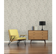 Woonkamer met fauteuil, commode, tafellamp en behang