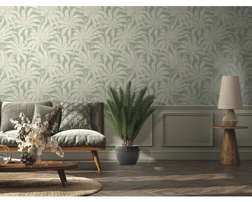 Woonkamer met bank, tafellamp en behang met plantenmotief