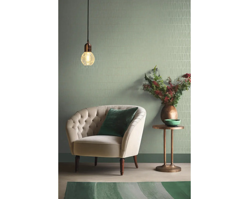 Woonkamer met fauteuil, bijzettafel, lamp en behang met patroon