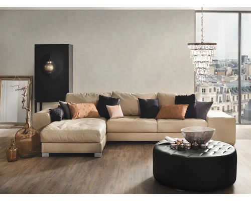 Woonkamer met beige hoekbank, zwarte decoratieve kast, ronde kruk en kristallen kroonluchter