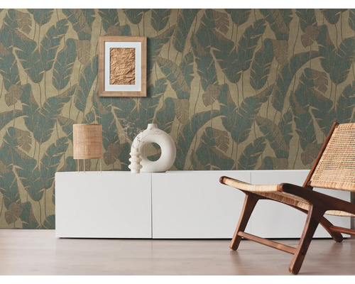 Woonkamer met behang met bladerenmotief, dressoir en fauteuil