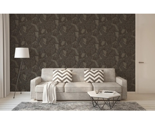 Woonkamer met bank, staande lamp en donker gemusterd behang met bladeren