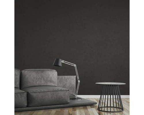 Woonkamer met bank, staande lamp en bijzettafel tegen een donkere muur