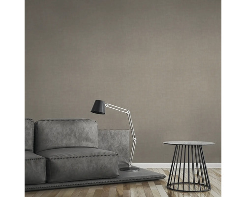 Woonkamer met bank, staande lamp en bijzettafel voor een gestructureerde wand