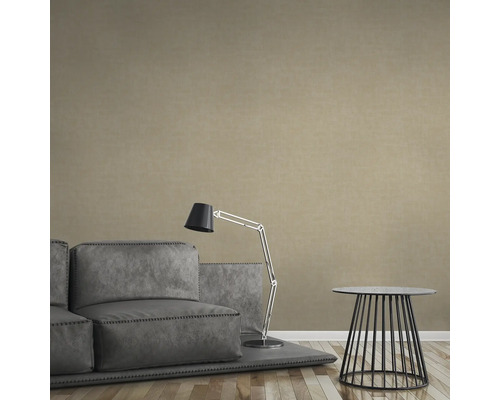 Beige vliesbehang in een woonkamer met bank, lamp en tafel.