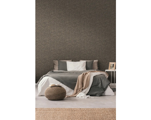 Slaapkamer met behang met motief, bed, kruk en tapijt voor een gezellige sfeer.