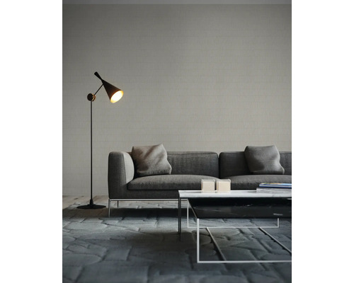 Woonkamer met bank, vloerlamp en salontafel op een tapijt