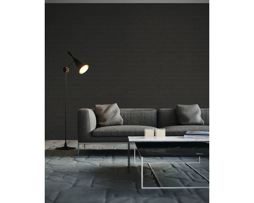 Woonkamer met grijze bank, staande lamp en donker gemustreerd behang