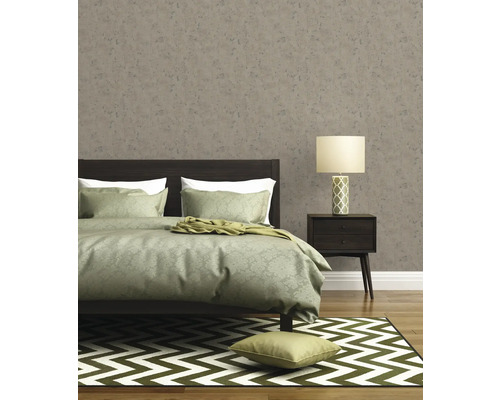 Slaapkamer met bed, nachtkastlamp, vloerkleed en behang met motief