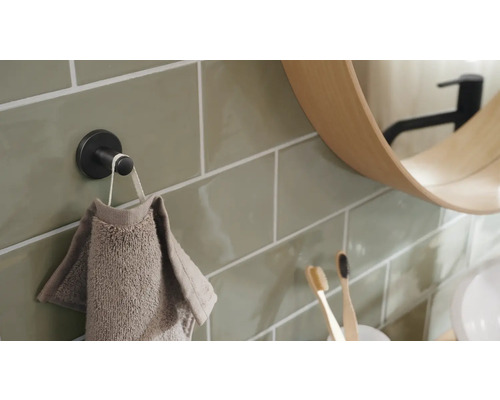 Detailopname van een badkamer met handdoekhaak, handdoek, spiegel en tandenborstels