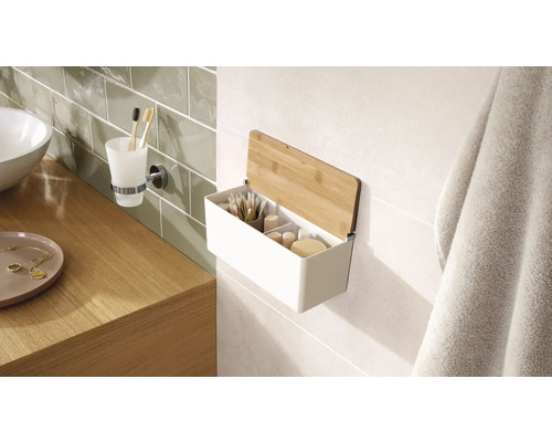 Badkamerscène met een wastafel, een tandenborstelbekerhouder en een wandplank met bamboe deksel voor het opbergen van badkamerbenodigdheden.