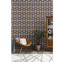 Woonkamer met patroonbehang, fauteuil, kamerplant en kast