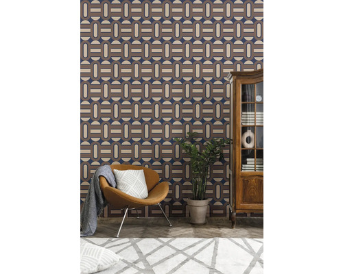 Woonkamer met patroonbehang, fauteuil, kamerplant en kast