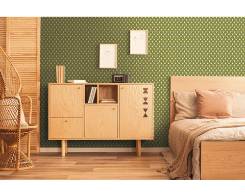 Kamer met groen behang met geometrisch patroon, houten kast, bed en rotan stoel.