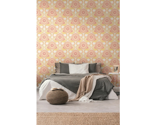 Een slaapkamer met bed en behang met patroon.