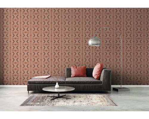 Woonkamer met behangpatroon, bank en vloerlamp.