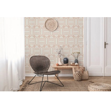 Lichte ruimte met geometrisch behang, rieten stoel, houten tafel en jute vloerkleed voor een vriendelijke sfeer.