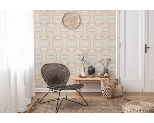 Lichte ruimte met geometrisch behang, rieten stoel, houten tafel en jute vloerkleed voor een vriendelijke sfeer.