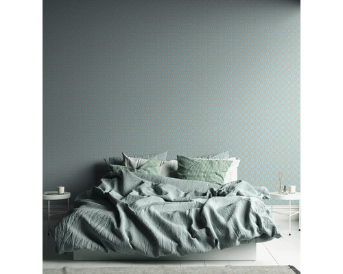 Slaapkamer met bed voor een behang met patroon