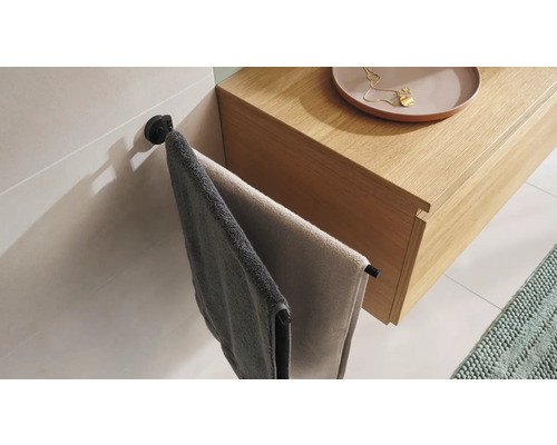 Twee handdoeken hangen aan een handdoekhouder naast een wastafel.