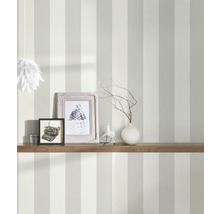 Ingerichte kamer met gestreept behang, plank, fotolijsten en decoratie