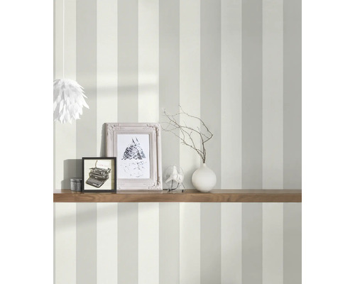 Ingerichte kamer met gestreept behang, plank, fotolijsten en decoratie