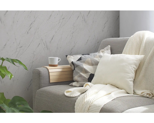 Woonkamer met grijze bank, kussens, deken en wandbekleding in marmerlook