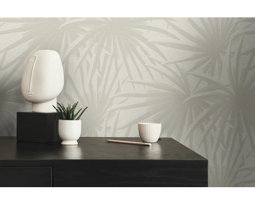 Moderne kamerdecoratie met een patroonbehang, een decoratief beeld en een kamerplant op een donker houten kastje