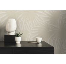 Scene met een patroonbehang, een sculptuur, een kamerplant en een kopje op een zwarte tafel