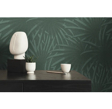 Interieur met groen bladbehang, sculptuur en plant op een tafel