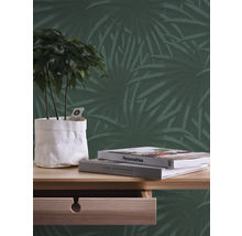 Decoratieve muur met palmmotief, tafel met plant en boeken
