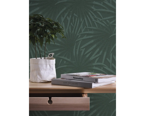 Decoratieve muur met palmmotief, tafel met plant en boeken