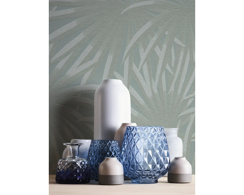 Diverse vazen voor een muur met bladmotief.