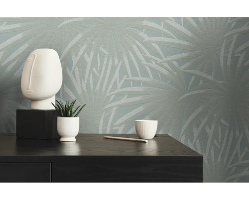 Scene met decoratief behang, decoratief figuur, plant en potlood op een commode