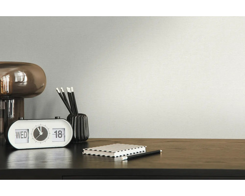 Close-up van een bureau met lamp, klok, pennen en notitieboek.