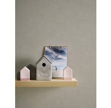 Decoratieve huizen van beton en hout op een plank, met een fotobord op de achtergrond
