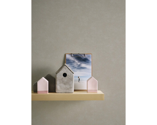 Decoratieve huizen van beton en hout op een plank, met een fotobord op de achtergrond